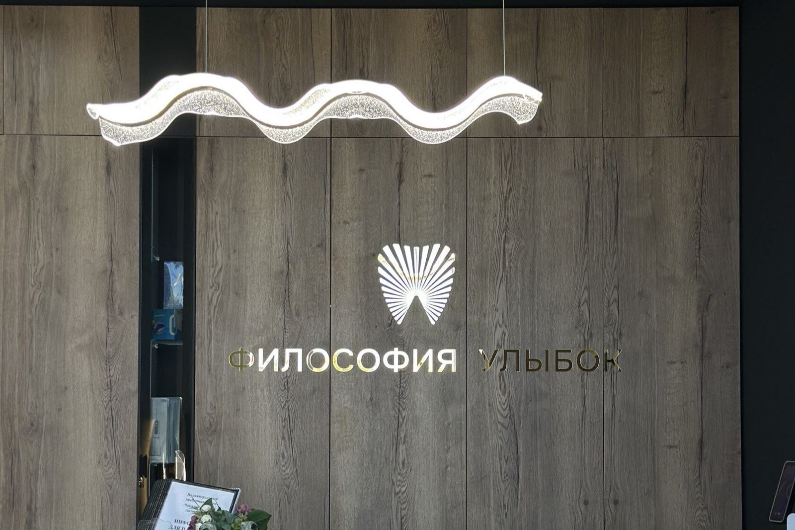 Ресепшн клиники с фирменным логотипом «Философия Улыбок»